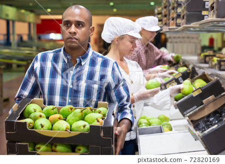 Man carrying box with pears at warehouse 72820169