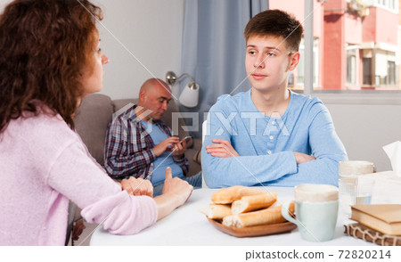 Boy talking to mother on background with indifferent father 72820214