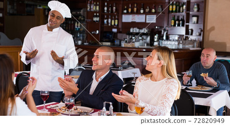Happy chef listens to praise of food in restaurant Happy chef listens to praise of food in restaurant 72820949