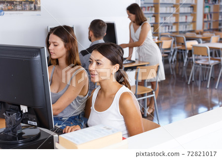 Girls using pc in library Girls using pc in library 72821017
