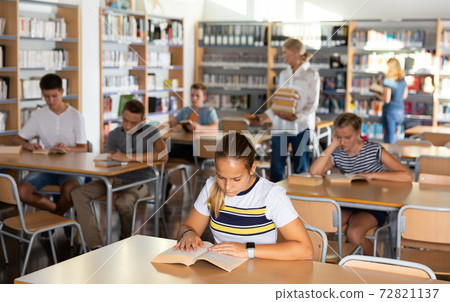Schoolers reading in college library 72821137
