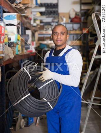 Male worker stocks plastic corrugation at store 72821243