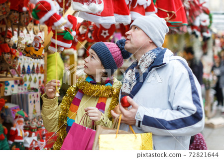 Girl with father choosing Xmas decoration Girl with father choosing Xmas decoration 72821644