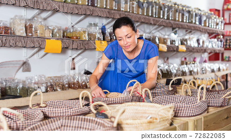 Woman taking dried beans with shovel from backet 72822085