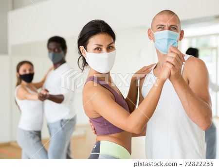 People in protective masks learning swing steps at dance class People in protective masks learning swing steps at dance class 72822235