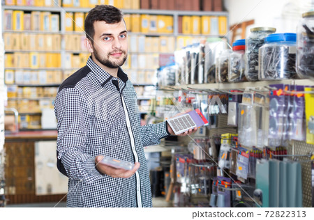 man deciding on best DIY details in houseware store man deciding on best DIY details in houseware store 72822313