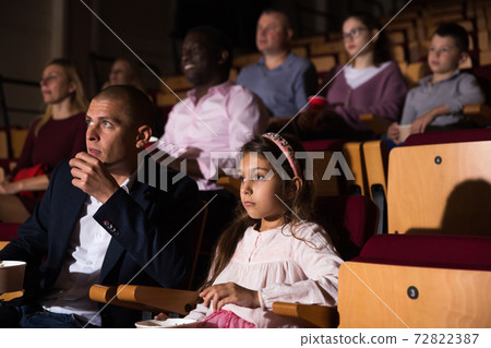 Family watching a movie in cinema hall 72822387