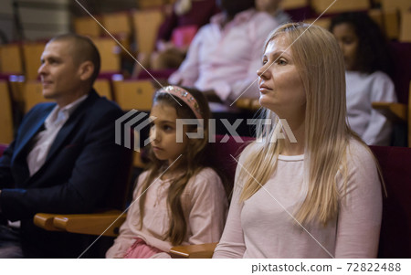 Portrait of a woman with interest watching a concert in the theater Portrait of a woman with interest watching a concert in the theater 72822488