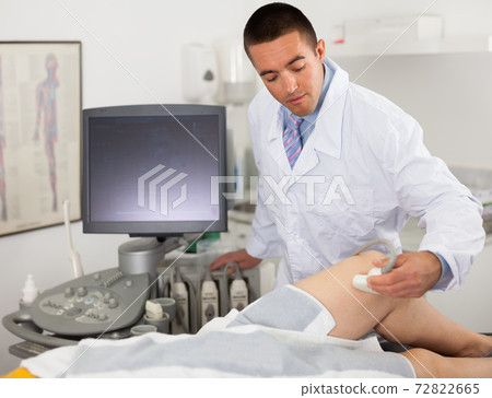 Man doctor during ultrasound test of woman Man doctor during ultrasound test of woman 72822665