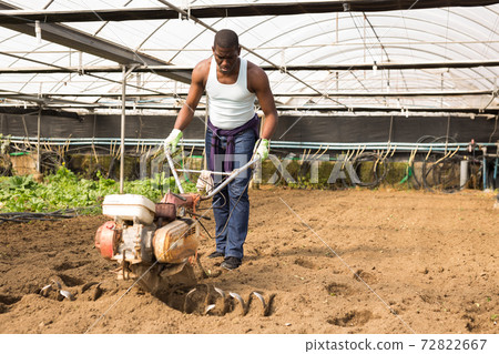 African man plowing ground with cultivator African man plowing ground with cultivator 72822667