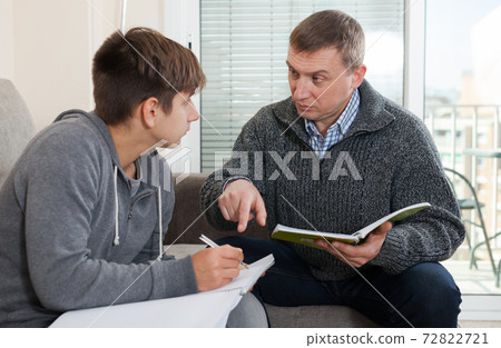Father helps son solve school assignments Father helps son solve school assignments 72822721