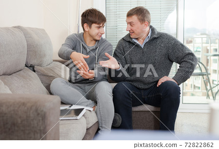 Father with his son are resting together and talking about teenage secrets 72822862