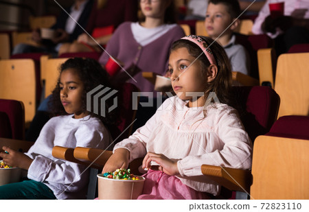 little female viewer sitting at premiere in cinema 72823110