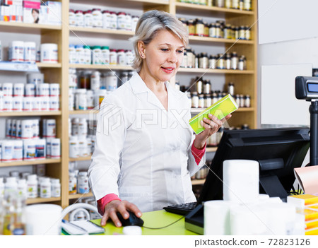 Smiling female seller checking assortment of care products 72823126