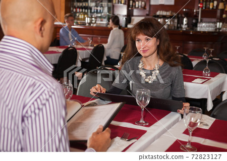 Girl with boyfriend choosing meal from menu Girl with boyfriend choosing meal from menu 72823127