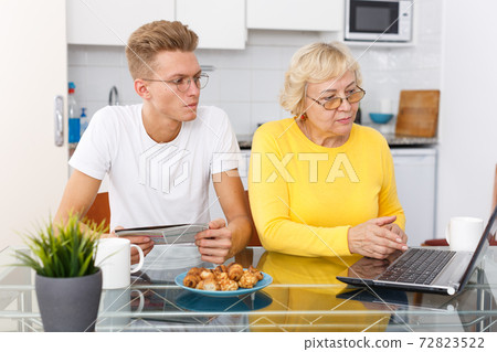 Woman and her son working with laptop Woman and her son working with laptop 72823522