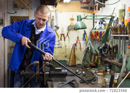 Lubricating and cleaning the barrel of rifle in gun workshop Lubricating and cleaning the barrel of rifle in gun workshop 72823568