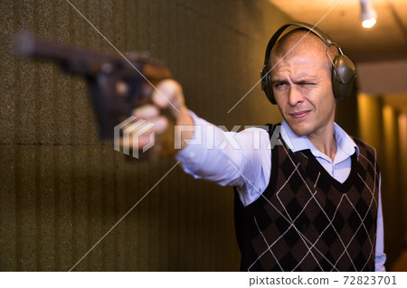 Shooter practicing sport handgun shooting at firing range 72823701