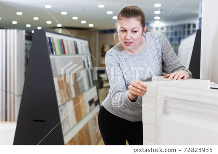 Young woman looking ceramic kitchen ceramic tile Young woman looking ceramic kitchen ceramic tile 72823935
