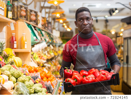Salesman holding box with red peppers 72824145
