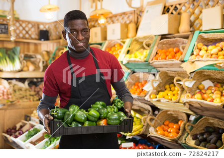 Salesman carrying box with green peppers 72824217