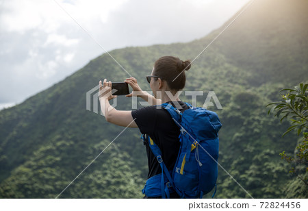 Woman hiker using smartphone on forest mountain top Woman hiker using smartphone on forest mountain top 72824456