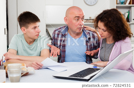 Chagrined family analyzing finances 72824531