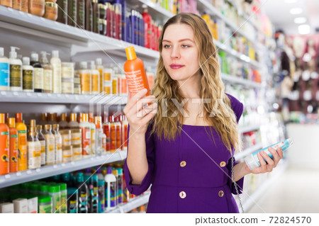 female chooses hair care cosmetics. 72824570