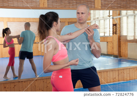 Self-defense workout with personal trainer in gym, martial art 72824776