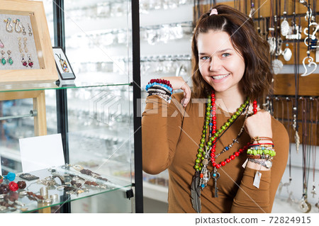 Girl seller offering fashionable bracelets and pendants Girl seller offering fashionable bracelets and pendants 72824915