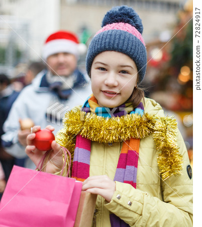 Smiling girl with father holding shopping bags Smiling girl with father holding shopping bags 72824917