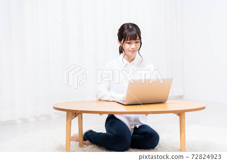 在客廳裡使用筆記本電腦的女士 72824923