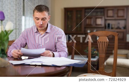 Man checking accountancy at home 72824929