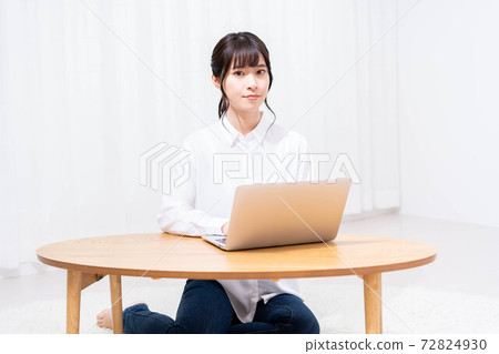 在客廳裡使用筆記本電腦的女士 72824930