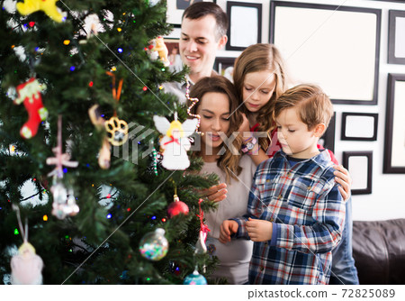 Family decorating Christmas tree 72825089