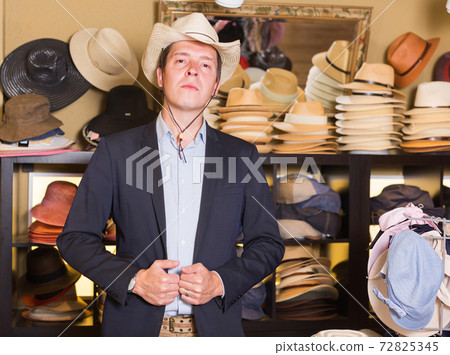 adult male try on western hat at the shopping center adult male try on western hat at the shopping center 72825345