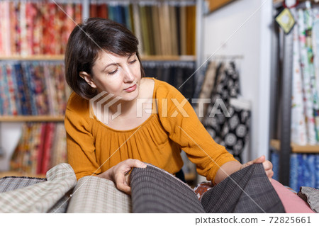 Woman choosing textiles in shop Woman choosing textiles in shop 72825661