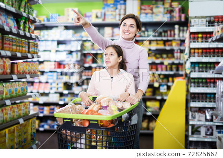Woman with daughter in supermarket Woman with daughter in supermarket 72825662