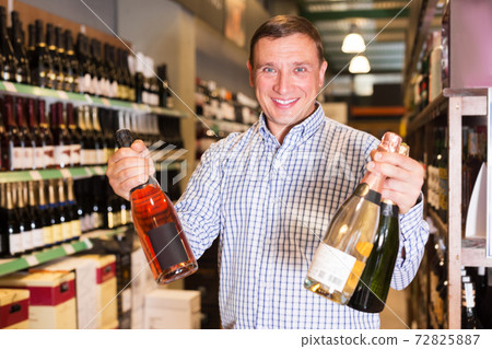 Man choosing wine in shop Man choosing wine in shop 72825887
