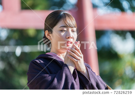 和服女人在寒冷中吹在她的手上 72826259