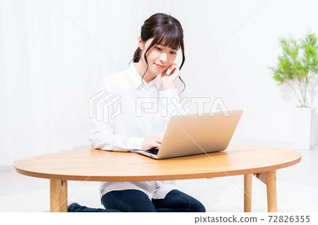 A lady who uses a laptop in the living room A lady who uses a laptop in the living room 72826355