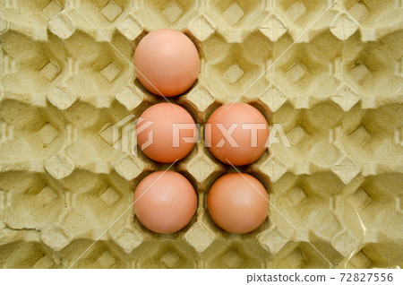 Fresh organic brown eggs in a carton package, protected paper yellow egg box Fresh organic brown eggs in a carton package, protected paper yellow egg box 72827556