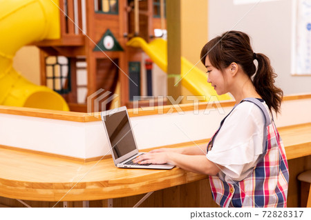 Nursery teacher / nursery / mom using a laptop 72828317