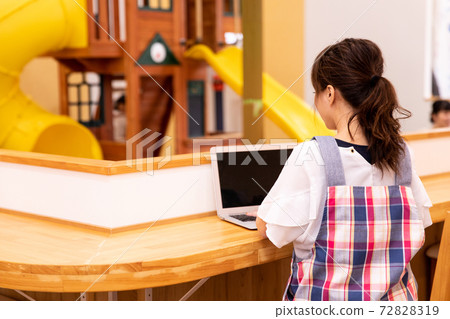 Nursery teacher / nursery / mom using a laptop 72828319