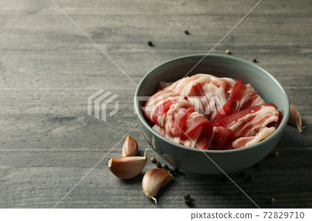 Bowl with bacon and spices on gray background Bowl with bacon and spices on gray background 72829710