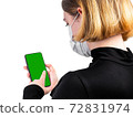 Young woman in medical protective mask with smartphone 72831974