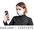 Young woman in medical protective mask with smartphone 72831975