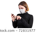 Young woman in medical protective mask with smartphone 72831977