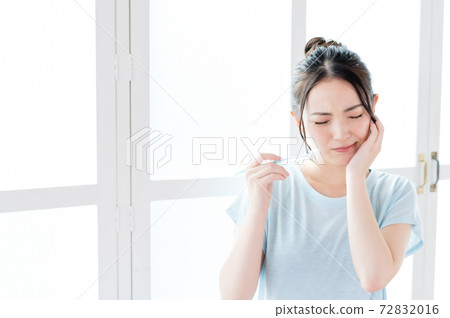 Young woman feeling pain in her teeth 72832016