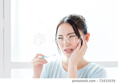 Young woman feeling pain in her teeth 72832039